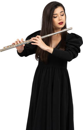 Vista frontal de uma jovem séria de vestido preto tocando flauta