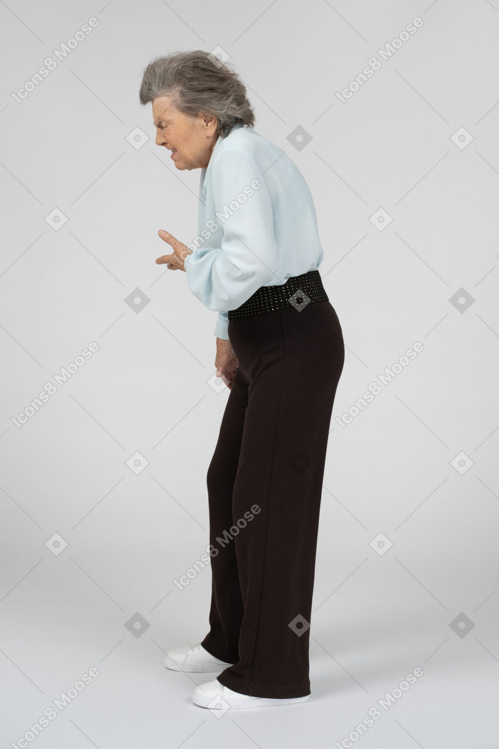Vista lateral de una anciana estornudando