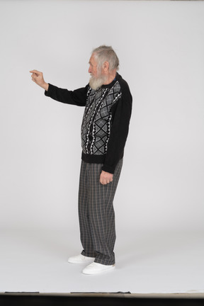 Side view of old man showing little gesture with fingers