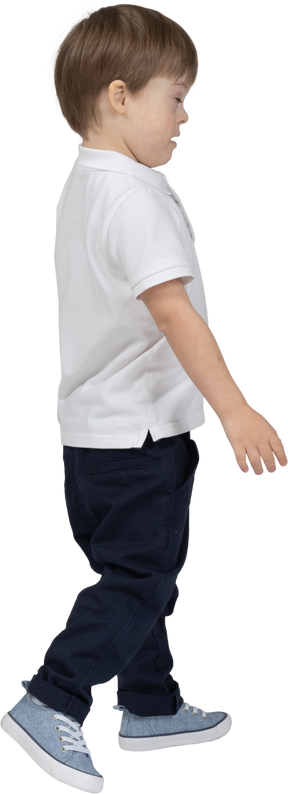 Vista lateral de um menino andando com os olhos fechados