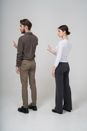 一对年轻夫妇在办公室服装伸出手中的四分之三视图