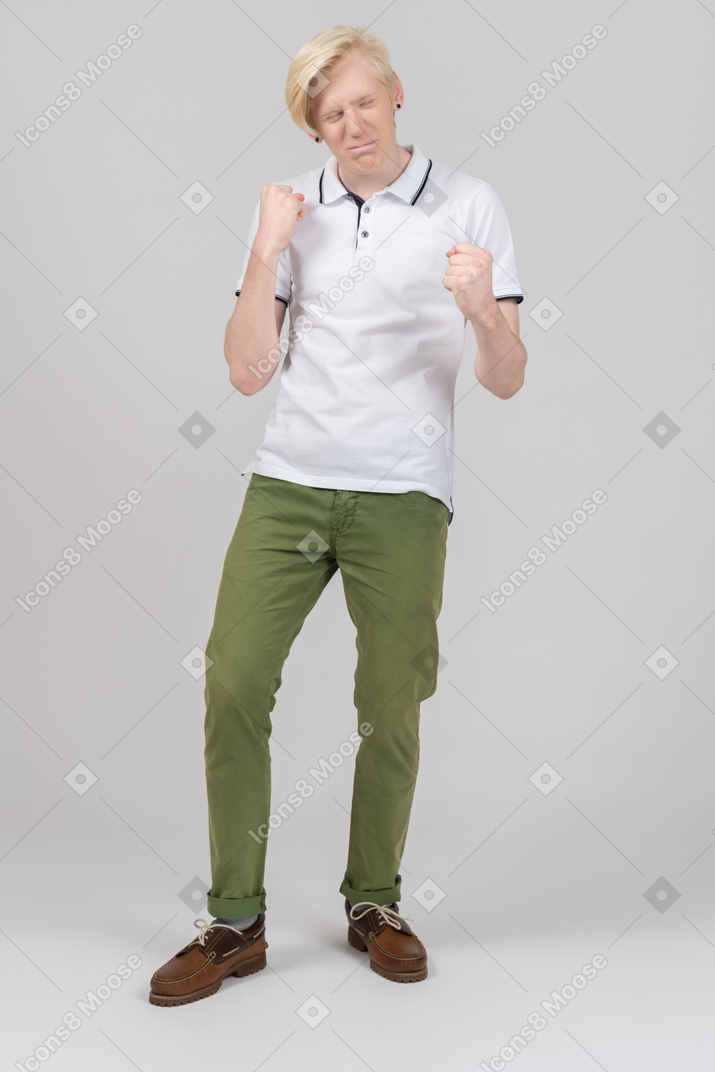 Cheerful young man with raised arms