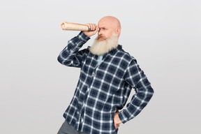 Bearded man looking through a paper tube