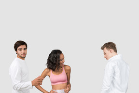 A man standing next to a woman checking out another man