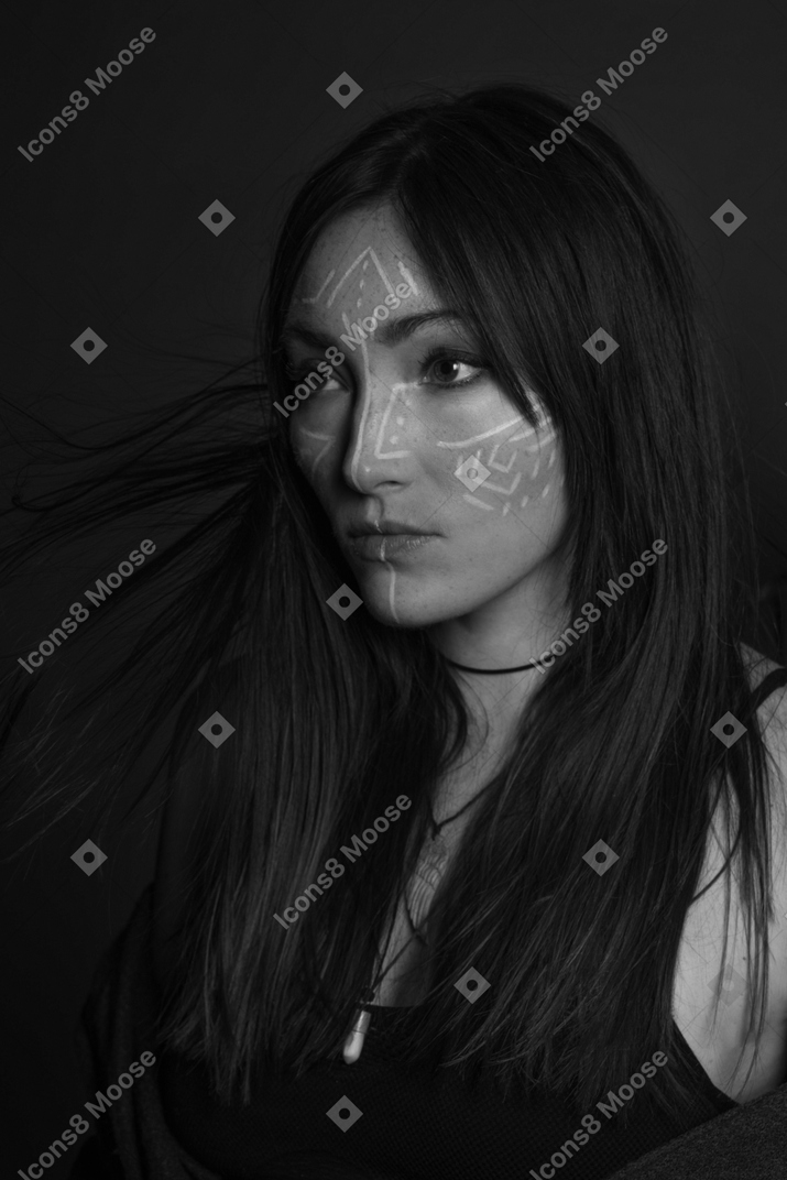 Retrato em preto e branco de uma jovem com arte no rosto