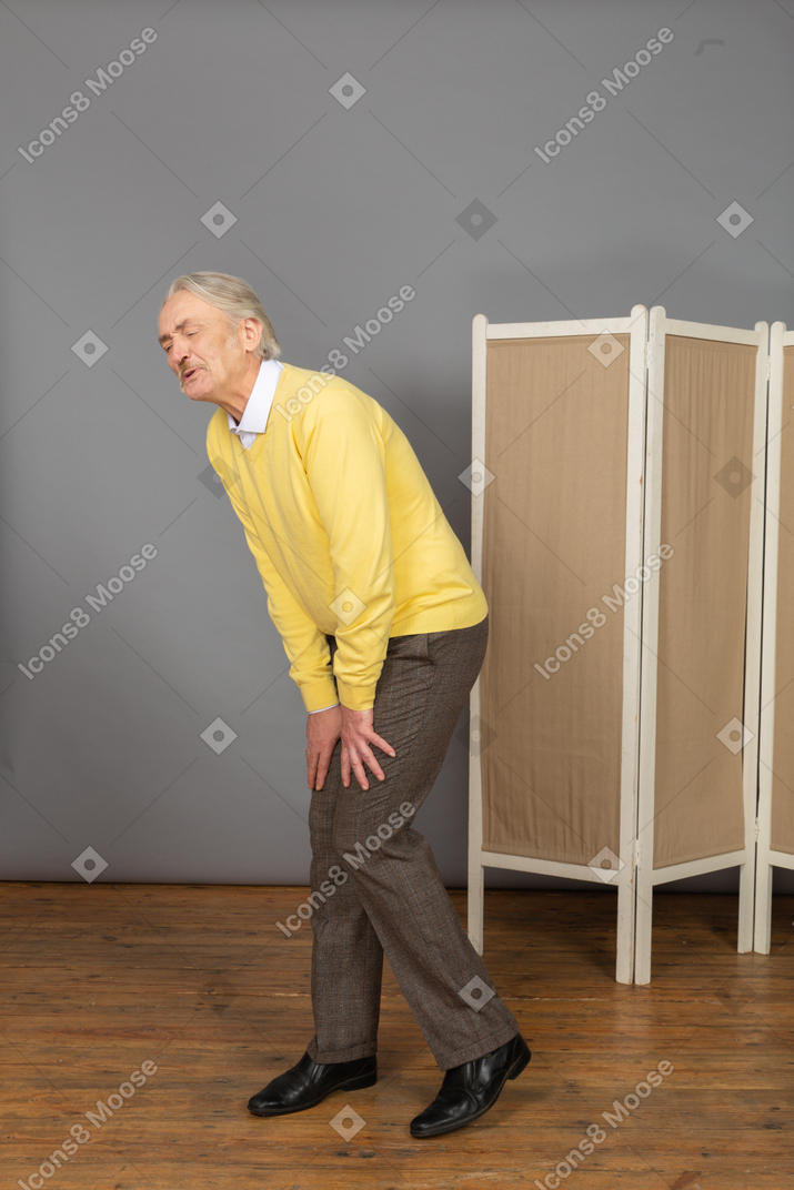 Three-quarter view of an old man having a knee ache
