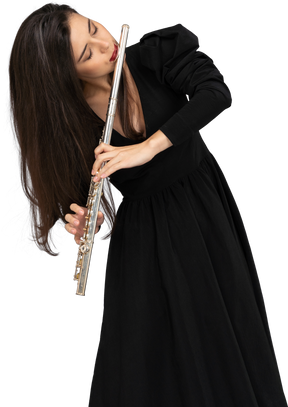 Front view of a serious young lady in black dress playing the flute