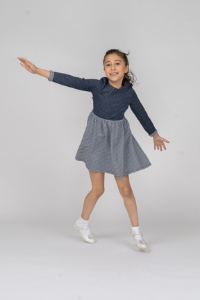 Three-quarter view of a girl imitating airplane in motion