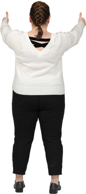Mulher plus size com suéter branco mostrando os polegares