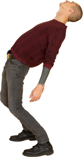 Side view of a young man in red pullover leaning back