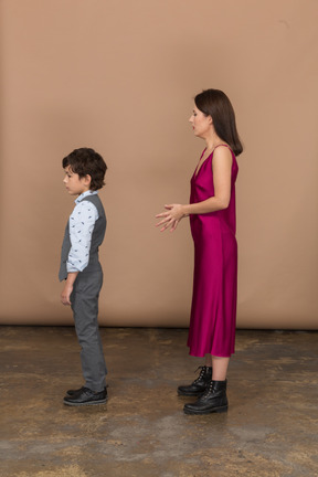 Young woman in red dress and boy standing still