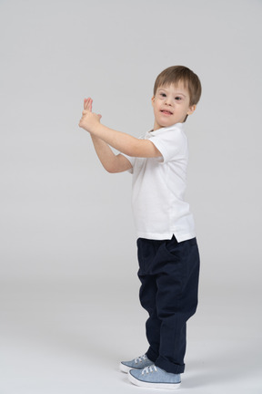 Side view of boy gesturing and looking at camera