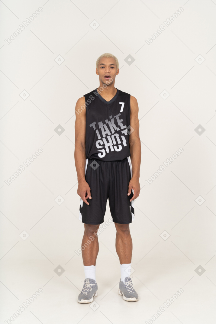 Vista frontal de um jovem jogador de basquete, parado com a boca aberta