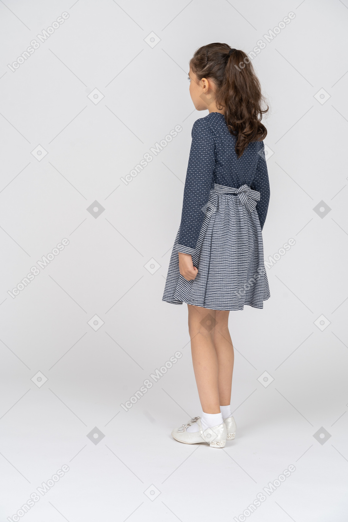Three-quarter back view of a girl taking a little step
