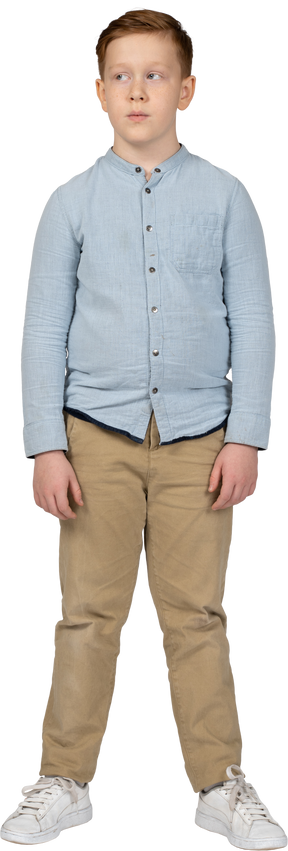 Vista frontal de un niño con ropa informal mirando a un lado