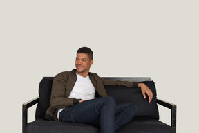 Smiling young man sitting on the sofa