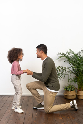 Young man on a knee with his daughter