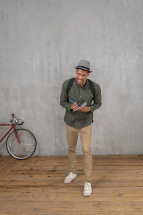 Man taking notes in notebook and smiling