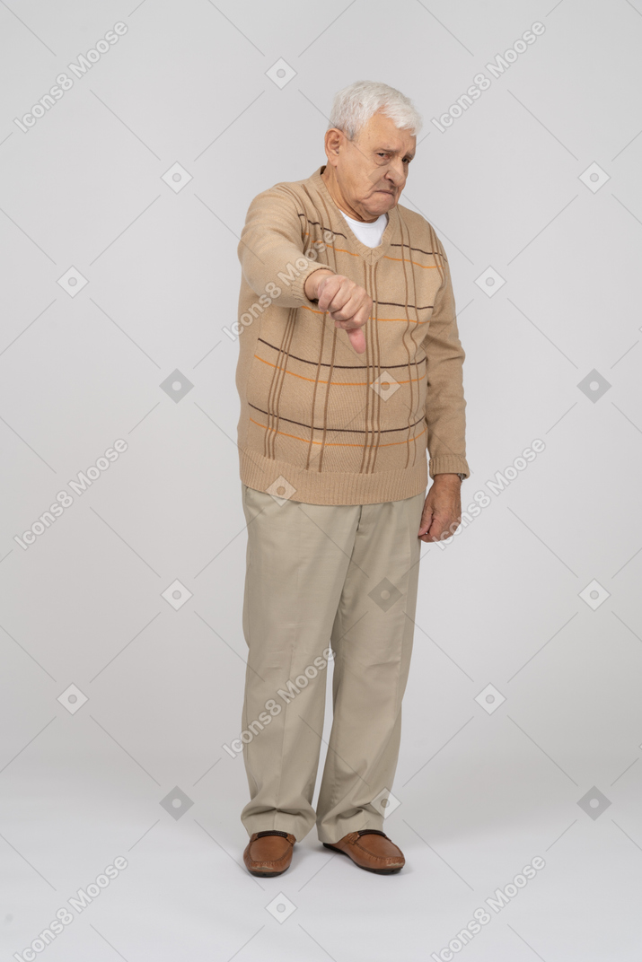 Front view of an old man in casual clothes showing thumb down