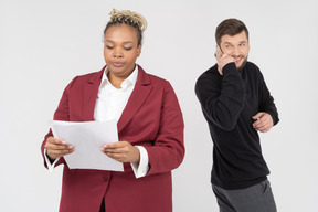 Joyeux jeune homme parlant au téléphone derrière le dos de son manager