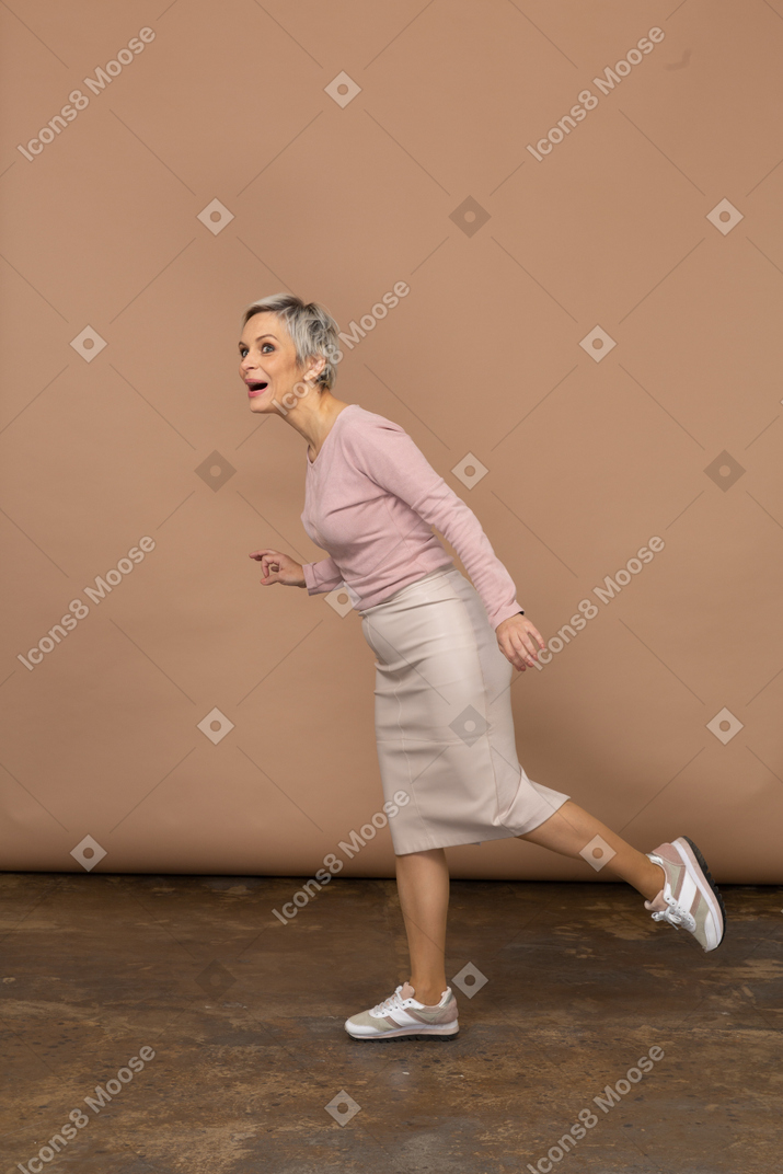 Impressed woman in casual clothes balancing on one leg