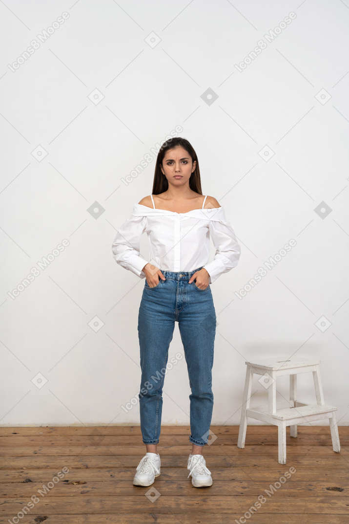 Front view of woman standing with hands in pockets