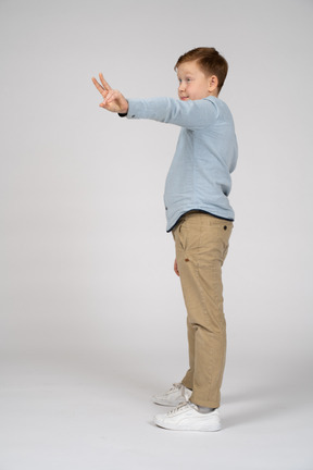 Side view of a boy showing v sign