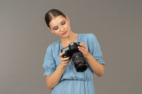 Vue de face d'une jeune femme souriante en bleu contrôle des photos