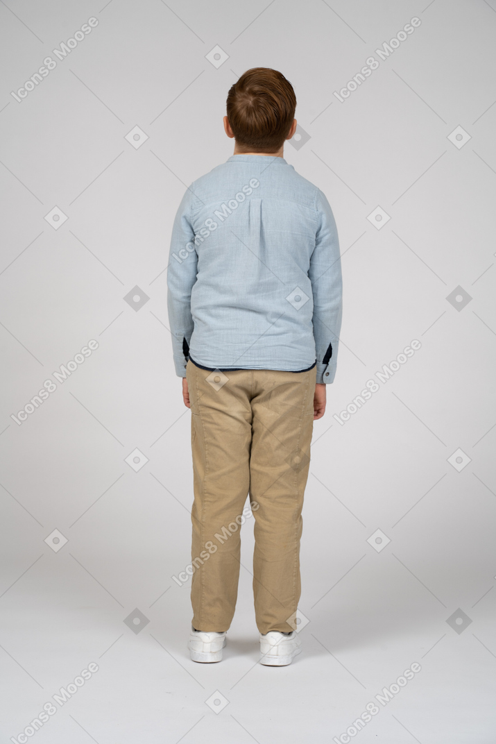 Vista traseira de um menino em roupas casuais, olhando para cima