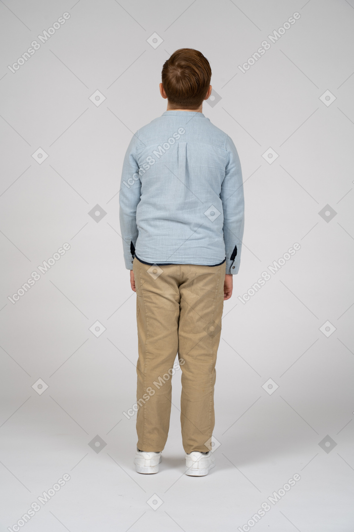 Rear view of a boy in casual clothes looking up