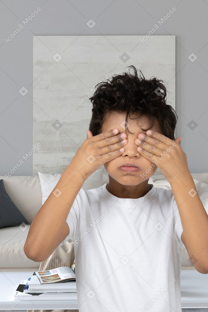 Small boy covering his eyes with hands
