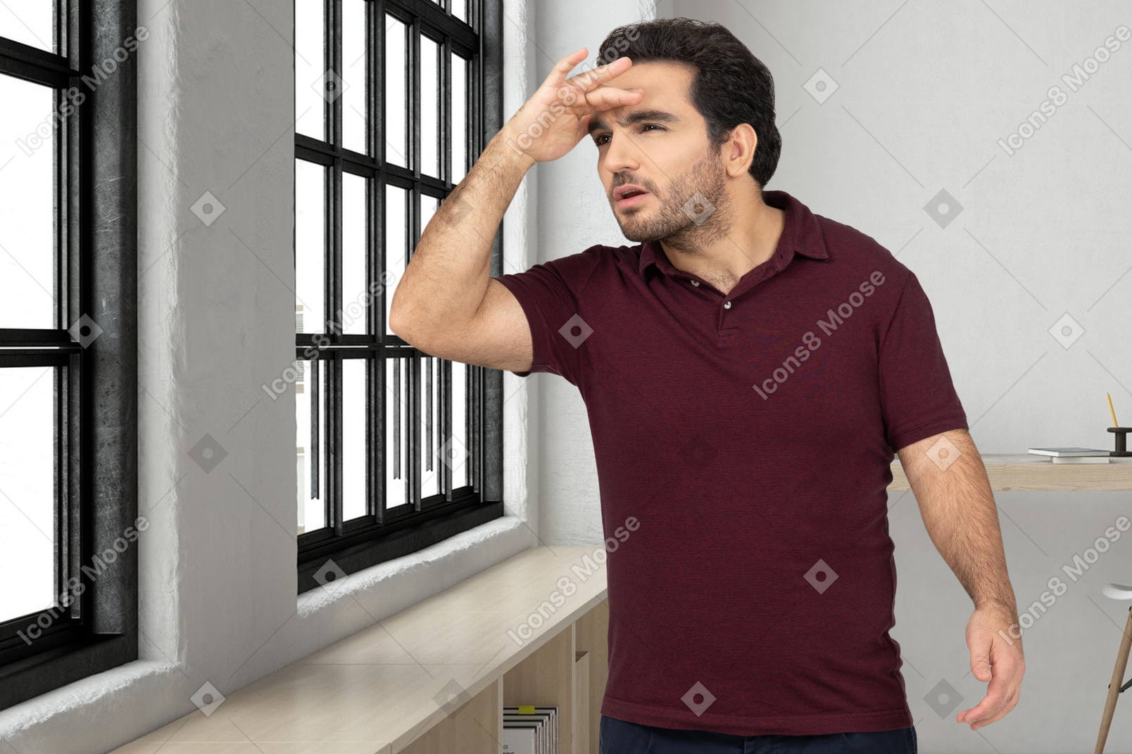 A man standing in front of a window and look into the distance