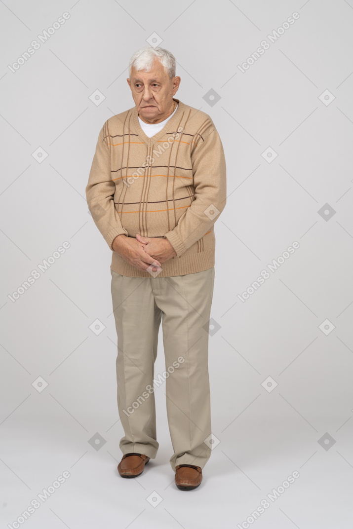 じっと立っているカジュアルな服装の老人の正面図