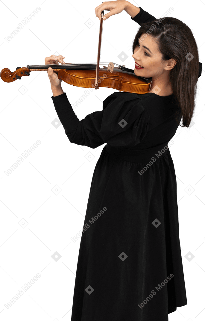 Close-up de uma jovem alegre de vestido preto tocando violino