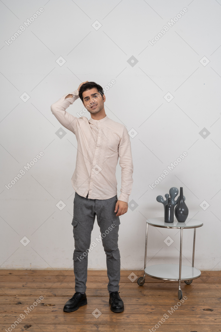 一个穿着休闲服的男人用手站在头后的前视图