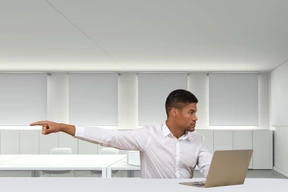 A man in a white shirt pointing to the right