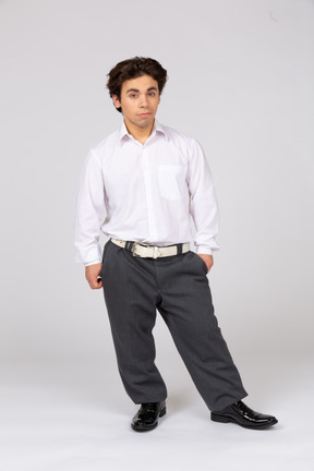 Front view of young man in office clothes looking at camera
