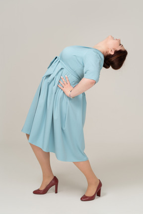 Side view of a woman in blue dress leaning back