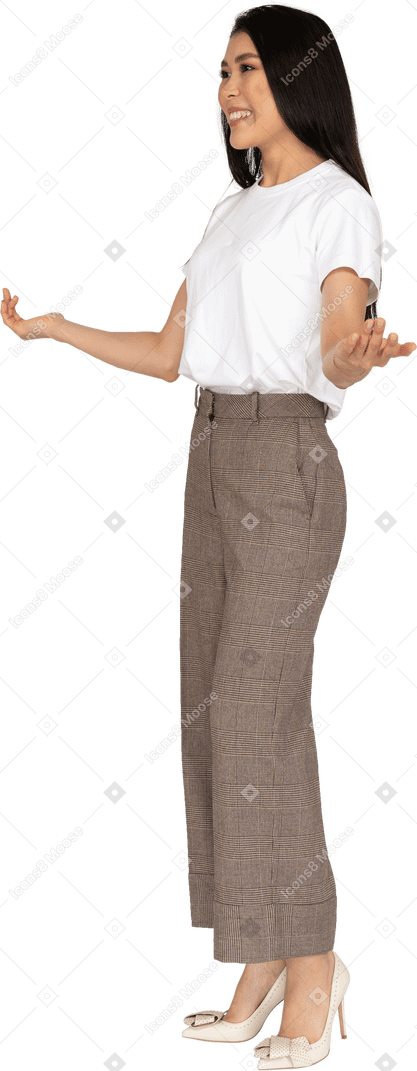 Трехчетвертный вид молодой женщины в бриджах, протягивающей руки
