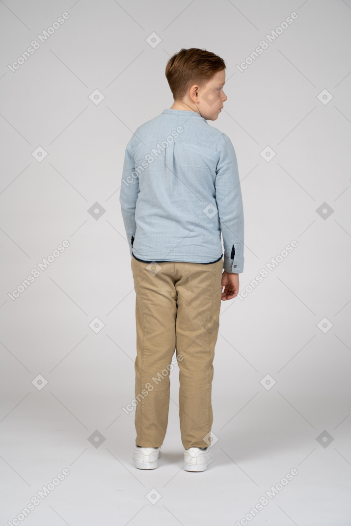 Rear view of a boy in casual clothes looking aside