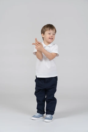 Niño sonriente sosteniendo su mano con los ojos cerrados