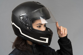 Una motociclista che apre una visiera per casco