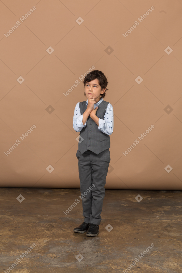 Vista frontale di un ragazzo premuroso in abito grigio