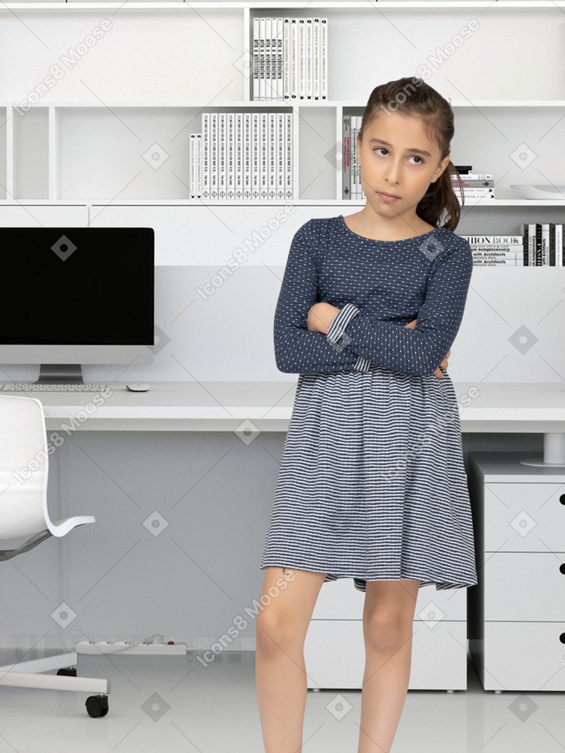 A young girl standing in front of a desk
