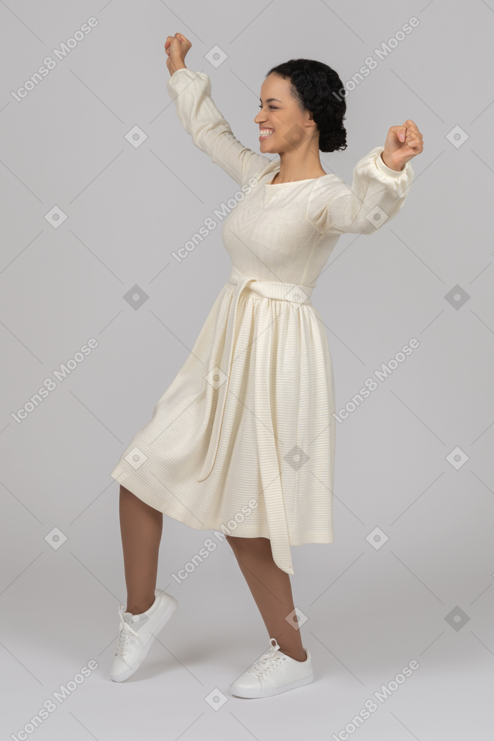 Excited young woman throwing her hands up
