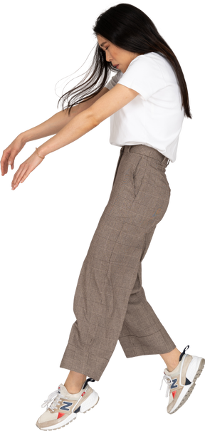 Side view of a young lady in breeches and t-shirt outstretching hands