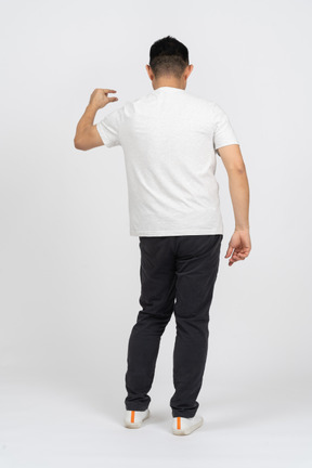 Rear view of a man in casual clothes showing size of something