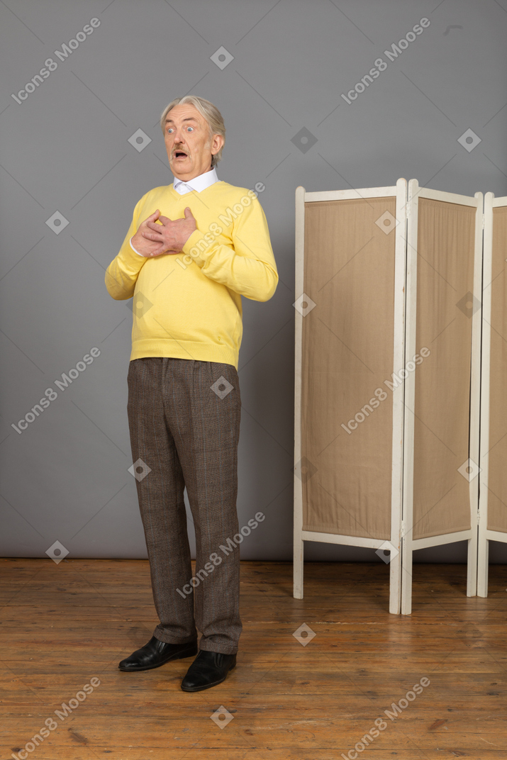 Three-quarter view of an astonished old man touching chest