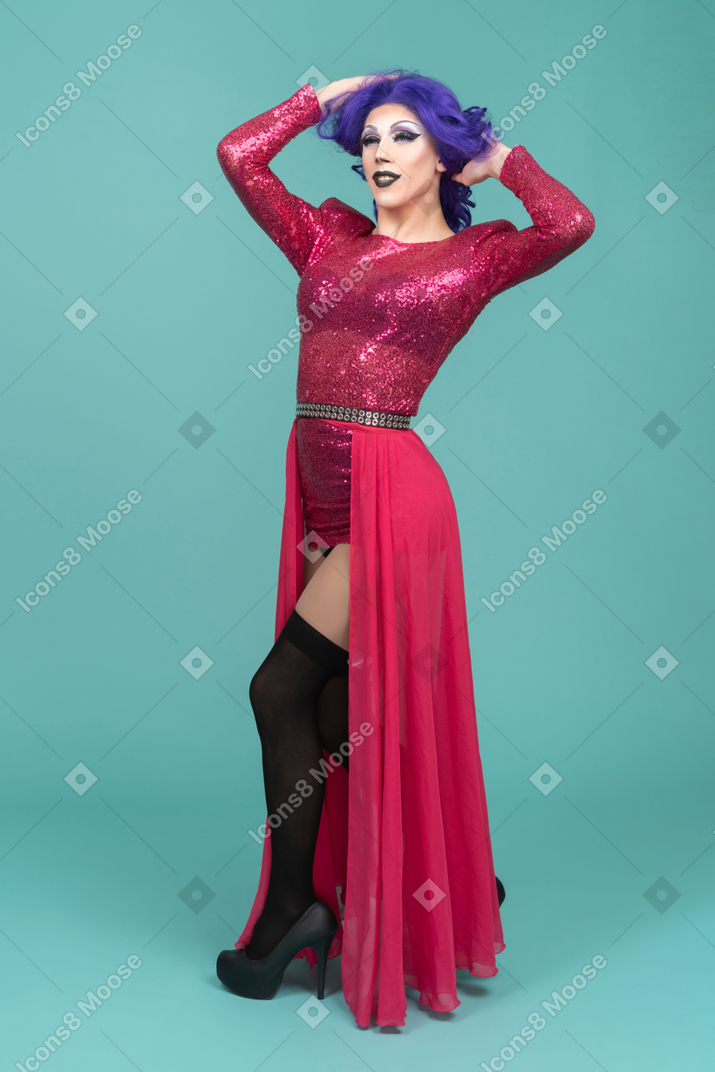 Drag queen in pink dress messing up hair & looking confident