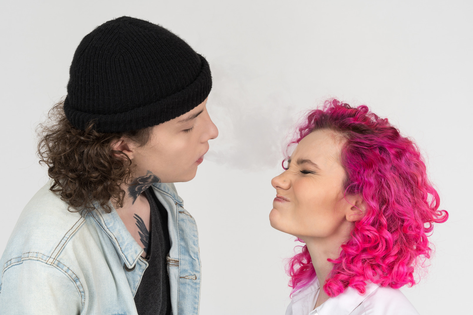 Male blowing smoke to his girlfriend's face
